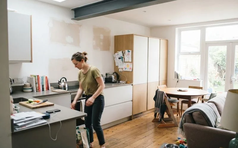 An open-plan kitchen and living space with a structural steel beam visible where an internal wall used to be
